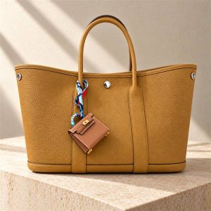 Hermès Garden Party tote handbag on a warm ivory limestone surface
